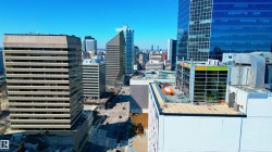 Urban skyline featuring a variety of high-rise buildings, including a prominent concrete and glass structure with horizontal window bands - 