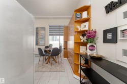 Entryway featuring built-in wood-finish shelving and a white wall with decorative frames - 
