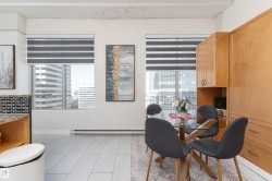 Dining area featuring a glass-top table, wood-finish flooring, and built-in wood cabinetry - 
