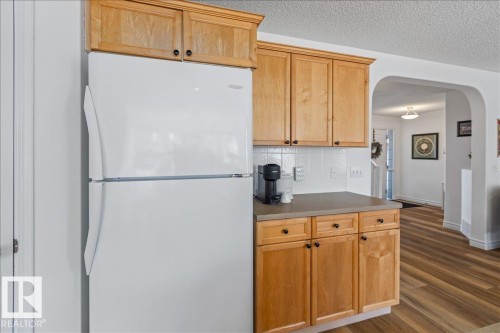 Kitchen area featuring light wood-finish cabinetry, solid surface countertops, and a white subway tile backsplash - 1130 Westerra Way, Stony Plain, AB - Indoor Photo Showing Kitchen