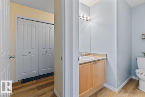Hallway with wood-finish flooring and bi-fold closet doors - 1130 Westerra Way, Stony Plain, AB - Indoor Photo Showing Bathroom