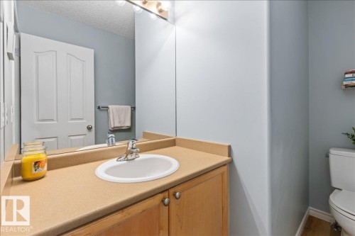 Vanity with integrated sink, laminate countertop, and wood-finish cabinetry - 1130 Westerra Way, Stony Plain, AB - Indoor Photo Showing Bathroom