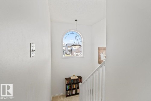 Vaulted ceiling with an arched window and suspended chandelier - 1130 Westerra Way, Stony Plain, AB - Indoor Photo Showing Other Room