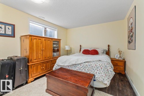 Wood-finish flooring with a cream area rug - 1130 Westerra Way, Stony Plain, AB - Indoor Photo Showing Bedroom