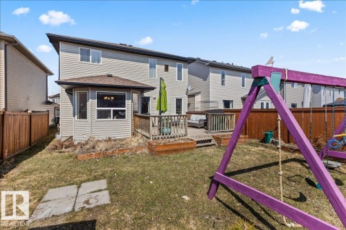 Rear exterior featuring light-toned siding, a multi-level wood deck, and a sunroom with multiple windows - 1130 Westerra Way, Stony Plain, AB - Outdoor