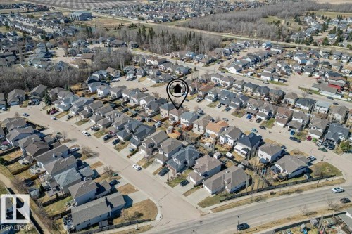Aerial perspective of a residential neighborhood featuring detached homes with asphalt shingle roofs and paved driveways - 1130 Westerra Way, Stony Plain, AB -  With View