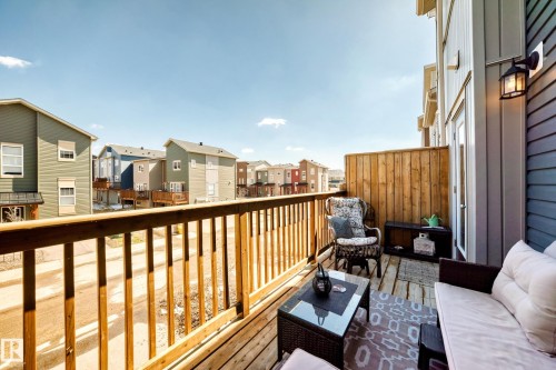 Private balcony with wood-plank flooring, wood railing, and privacy fence - 115 401 Southfork Drive, Leduc, AB - Outdoor With Balcony With Exterior