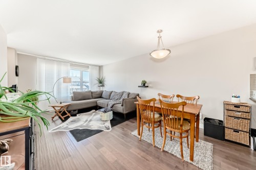 Open-concept living area with dark wood-finish flooring - 115 401 Southfork Drive, Leduc, AB - Indoor