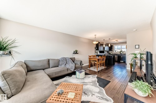 Open-concept living area featuring rich wood-finish flooring, neutral wall tones, and recessed lighting - 115 401 Southfork Drive, Leduc, AB - Indoor Photo Showing Living Room