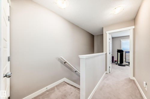 Upper-level hallway featuring neutral wall tones, white trim, and carpeted flooring - 115 401 Southfork Drive, Leduc, AB - Indoor Photo Showing Other Room
