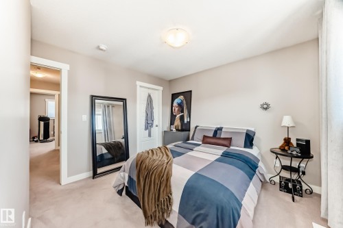 Plush carpeting in a neutral tone, crisp white baseboards, and a ceiling-mounted light fixture - 115 401 Southfork Drive, Leduc, AB - Indoor Photo Showing Bedroom