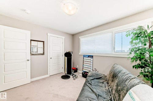 Room featuring light beige wall paint, white trim, two white paneled doors with chrome hardware, and a horizontal window with blinds - 115 401 Southfork Drive, Leduc, AB - Indoor