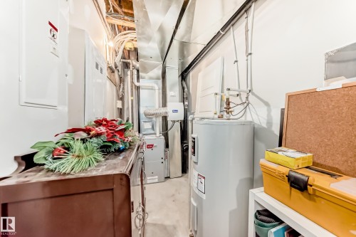 Utility area featuring a water heater, furnace, exposed ductwork, and electrical panels - 115 401 Southfork Drive, Leduc, AB - Indoor Photo Showing Basement