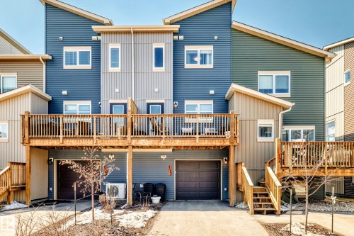 Contemporary multi-level townhome exteriors featuring horizontal and vertical siding in varied tones - 115 401 Southfork Drive, Leduc, AB - Outdoor With Balcony With Deck Patio Veranda With Exterior