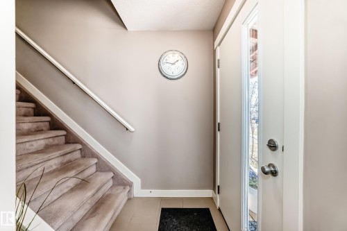 Entryway featuring a staircase with carpeted treads and a handrail - 115 401 Southfork Drive, Leduc, AB - Indoor Photo Showing Other Room