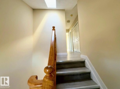 Staircase featuring wood railing and painted risers with a skylight overhead - 10905 74 Avenue, Edmonton, AB - Indoor Photo Showing Other Room