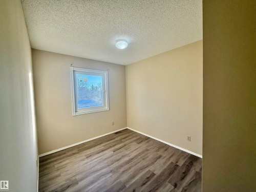Neutral wall tones complement the wood-finish flooring - 10905 74 Avenue, Edmonton, AB - Indoor Photo Showing Other Room