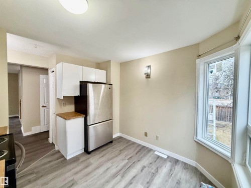 Kitchen area featuring light wood-finish flooring and a bay window - 10905 74 Avenue, Edmonton, AB - Indoor Photo Showing Kitchen