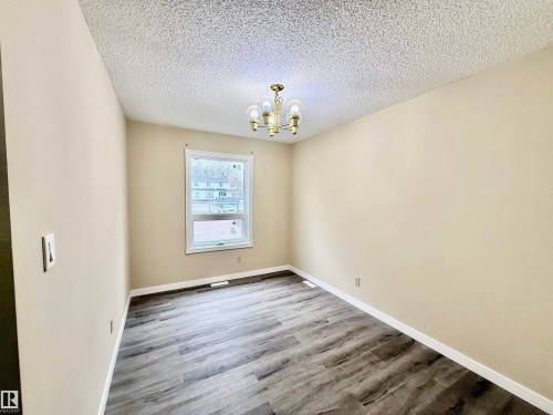 Room featuring wood-finish flooring, neutral wall paint, and a white trim package - 10905 74 Avenue, Edmonton, AB - Indoor Photo Showing Other Room