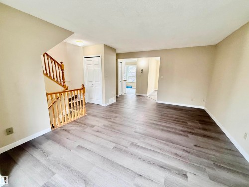 Spacious room featuring wood-finish flooring and neutral wall tones - 10905 74 Avenue, Edmonton, AB - Indoor Photo Showing Other Room