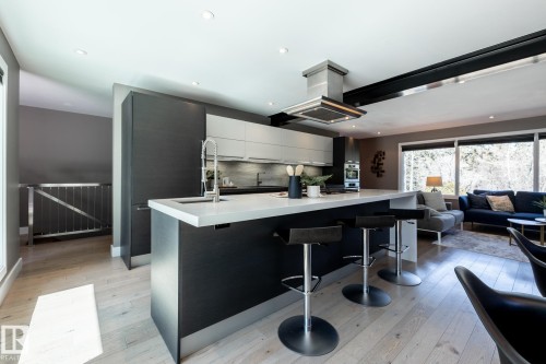Modern kitchen featuring a large island with white countertop, integrated sink, and stainless steel faucet - 4204 Aspen Drive E, Edmonton, AB - Indoor Photo Showing Kitchen With Upgraded Kitchen