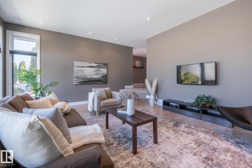 Spacious living area featuring light wood-finish flooring, recessed lighting, and large windows with integrated window treatments - 4204 Aspen Drive E, Edmonton, AB - Indoor Photo Showing Living Room