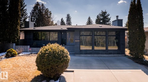 Contemporary residence featuring a dark-toned exterior facade with large, reflective windows - 4204 Aspen Drive E, Edmonton, AB - Outdoor