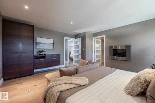Expansive room featuring light wood-finish flooring and a built-in wall unit with dark wood-finish cabinetry - 4204 Aspen Drive E, Edmonton, AB - Indoor Photo Showing Bedroom