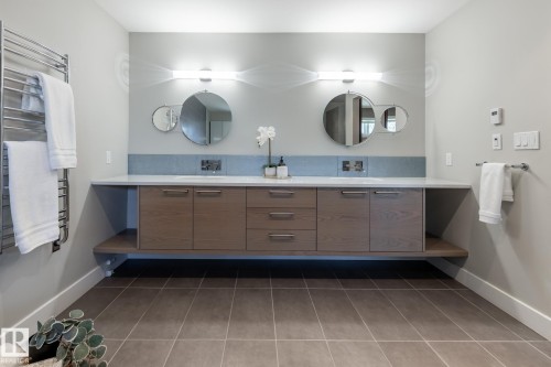 Floating wood-finish vanity with dual sinks, stone countertop, and integrated storage - 4204 Aspen Drive E, Edmonton, AB - Indoor Photo Showing Bathroom