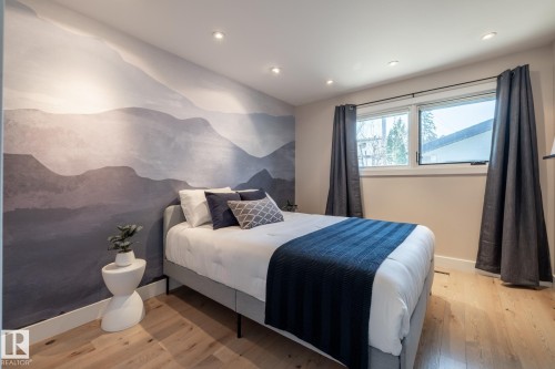Accent wall featuring a scenic mural, recessed ceiling lighting, light wood-finish flooring, and a large window with white trim - 4204 Aspen Drive E, Edmonton, AB - Indoor Photo Showing Bedroom