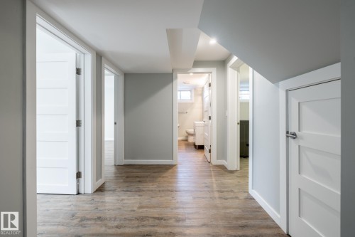 Hallway featuring wood-finish flooring, white paneled doors, recessed lighting, and light gray wall paint - 4204 Aspen Drive E, Edmonton, AB - Indoor Photo Showing Other Room