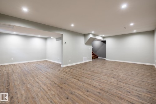 Spacious lower level featuring wood-finish flooring, recessed lighting, and light gray walls - 4204 Aspen Drive E, Edmonton, AB - Indoor
