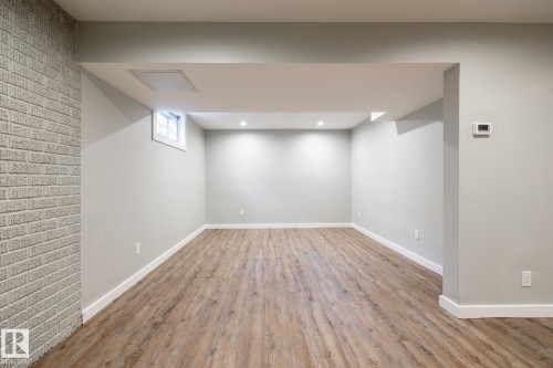 Spacious room featuring wood-finish flooring, light grey painted walls, recessed lighting, and white baseboards - 4204 Aspen Drive E, Edmonton, AB - Indoor Photo Showing Other Room
