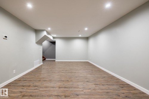Spacious room featuring wood-finish flooring, light grey walls, white baseboards, and recessed ceiling lighting - 4204 Aspen Drive E, Edmonton, AB - Indoor Photo Showing Other Room