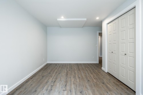 Neutral tone walls showcasing wood-finish flooring, recessed lighting, and a built-in bi-fold closet - 4204 Aspen Drive E, Edmonton, AB - Indoor Photo Showing Other Room