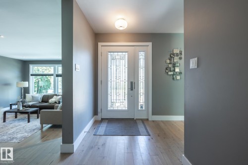 Entryway featuring light wood-finish flooring and a decorative double door with frosted glass panels - 4204 Aspen Drive E, Edmonton, AB - Indoor Photo Showing Other Room