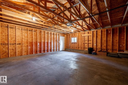 Spacious garage with exposed wood trusses and unfinished OSB walls - 4204 Aspen Drive E, Edmonton, AB - Indoor