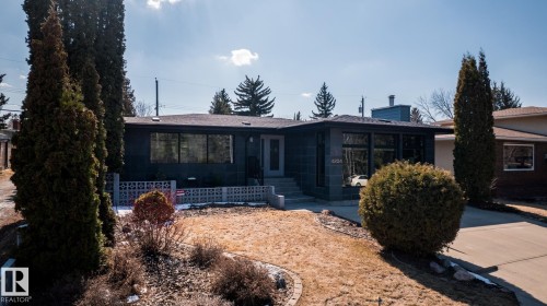 Modern single-story residence featuring a dark facade with prominent windows - 4204 Aspen Drive E, Edmonton, AB - Outdoor