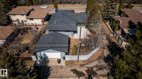 Aerial perspective showcasing a light blue residence with a dark shingled roof, accompanied by a detached garage featuring a white overhead door and matching shingled roof - 4204 Aspen Drive E, Edmonton, AB - Outdoor
