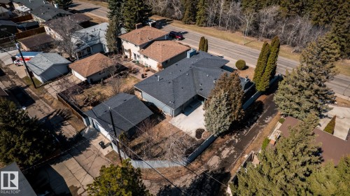 Expansive residential property featuring a gray shingle roof, a paved driveway, and mature perimeter trees - 4204 Aspen Drive E, Edmonton, AB - Outdoor With View