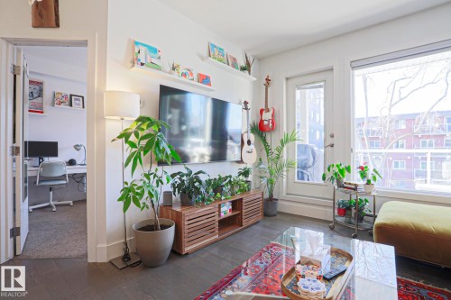 Living area featuring dark wood-finish flooring, a white baseboard, and a white wall finish - 202 10030 83 Avenue, Edmonton, AB - Indoor Photo Showing Other Room