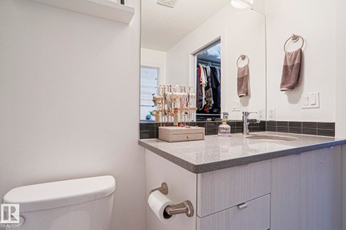 Modern vanity featuring a gray speckled countertop, undermount sink, and chrome faucet - 202 10030 83 Avenue, Edmonton, AB - Indoor Photo Showing Bathroom