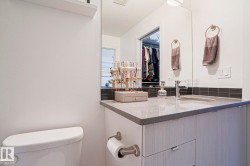 Modern vanity featuring a gray speckled countertop, undermount sink, and chrome faucet - 
