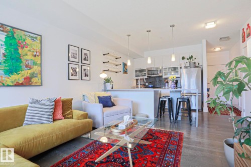 Open-concept living area with dark wood-finish flooring, white walls, and recessed lighting - 202 10030 83 Avenue, Edmonton, AB - Indoor Photo Showing Living Room
