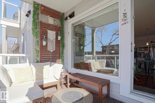 Inviting outdoor patio featuring slatted wood wall panels, a wood-finish floor, and a large sliding glass door - 202 10030 83 Avenue, Edmonton, AB -  With Exterior
