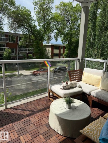 Private balcony featuring wood-finish flooring tiles and a glass railing - 202 10030 83 Avenue, Edmonton, AB - Outdoor With Deck Patio Veranda