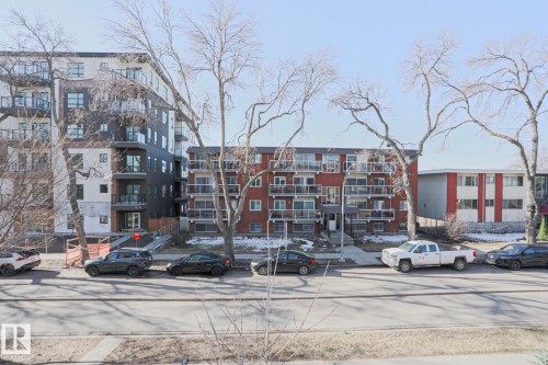 Modern multi-story building featuring dark paneling and light-colored siding - 202 10030 83 Avenue, Edmonton, AB - Outdoor With Facade