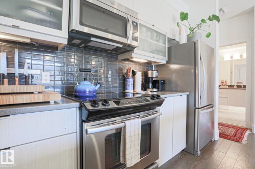 Modern kitchen with stainless steel appliances, including an electric range and microwave - 202 10030 83 Avenue, Edmonton, AB - Indoor Photo Showing Kitchen