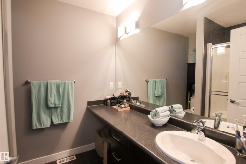 Bathroom vanity with an integrated oval sink and chrome faucet, set against a full-width mirror - 3805 170A Avenue, Edmonton, AB - Indoor Photo Showing Bathroom