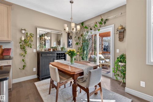 Dining area featuring wood-finish flooring and a contemporary chandelier - 2313 Sparrow Crescent, Edmonton, AB - Indoor Photo Showing Dining Room